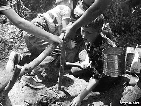 Boys help prepare a camp fire at 1950s summer camp