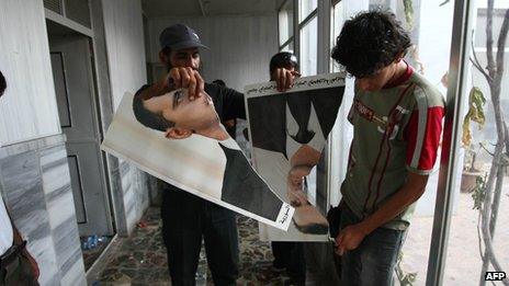 Syrian rebel FSA soldiers tear up a poster of President Bashar al-Assad