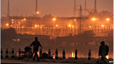 In this photograph taken on December 9, 2009 pedestrians walk on a roadside past a power sub-station in the outskirts of Kolkata. India"s northern electricity grid which covers an area home to more than 300 million people failed for the second day in a row on July 31, 2012, with the eastern network also down, an official said. A