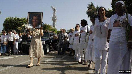 Members of the "Ladies in White" opposition group march beside the funeral procession of Oswaldo Paya on 24 July 2012