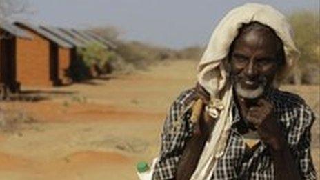 A Somali refugee and goat herder walks past unoccupied refugee housing at Ifo II