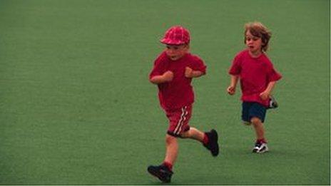 Two children running across school field