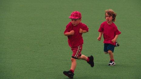 Two children running across school field