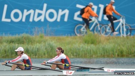 Cyclists watching rowers