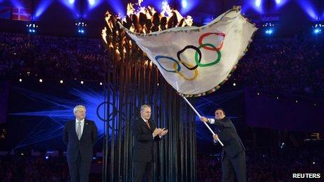 Rio de Janeiro Mayor Eduardo Paes waves the Olympic flag as IOC President Jacques Rogge applauds and London Mayor Boris Johnson watches