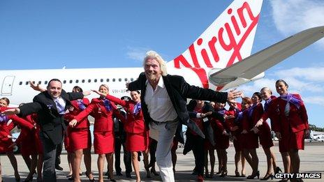 Richard Branson posing with crew by a Virgin aeroplane