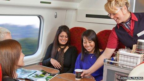 Train attendant serving coffee to passenger