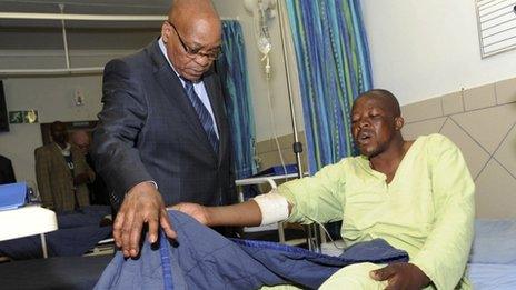 South Africa's President Jacob Zuma (L) chats with one of the injured miners during a courtesy visit in a hospital outside a South African mine in Rustenburg, 100km (62 miles) northwest of Johannesburg, 17 August 2012