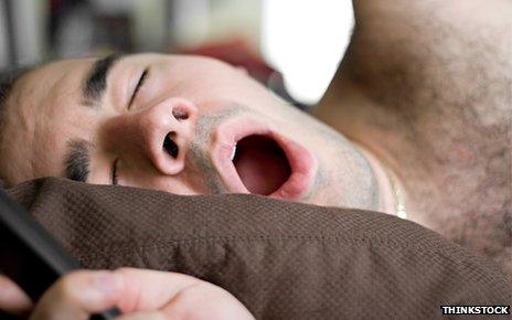 Man yawning in bed