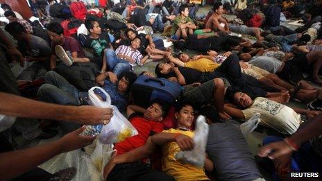 Volunteers from a non-governmental organisation (NGO) distribute free food to the people from India"s northeastern states waiting for the train bound for the Assam state at a railway station in Kolkata August 19, 2012