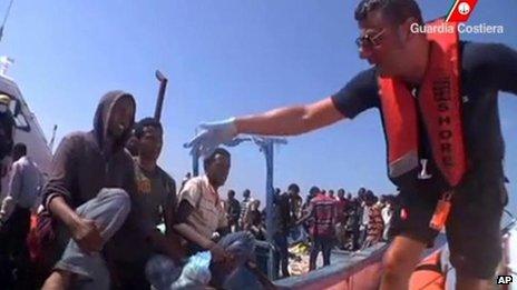 A still frame from video footage of an Italian coast guard reaching a vessel overcrowded with migrants from mainly Tunisia and sub-Saharan Africa