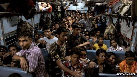 Indian migrant workers pile into a train as they flee Bangalore