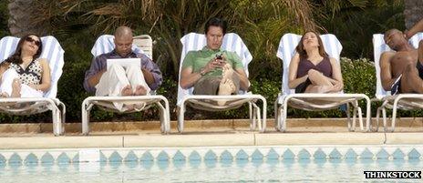 Line of deckchairs with people using laptops and smartphones