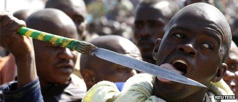 A protester licks his spear at the Lonmin-owned mine in South Africa (16 August 2012)