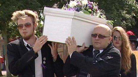 Two men carry a coffin as part of Save the Harlan Beagles' march through Cambridge