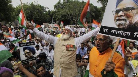 Indian protesters hold photographs of Indian Prime Minister Manmohan Singh as they shout slogans during an anti corruption protest near the Indian parliament in New Delhi, India, Sunday, Aug. 26, 2012