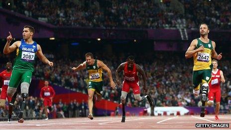 Alan Fonteles Cardoso Oliveira of Brazil crosses the line ahead of Oscar Pistorius of South Africa to win gold in the Men's 200m in 2012 Paralympics