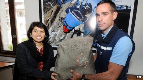 A French official hands over the diplomatic bag to Satwant Khanalia, an Indian embassy official in Paris, on 3 September 2012 in Chamonix, French Alps