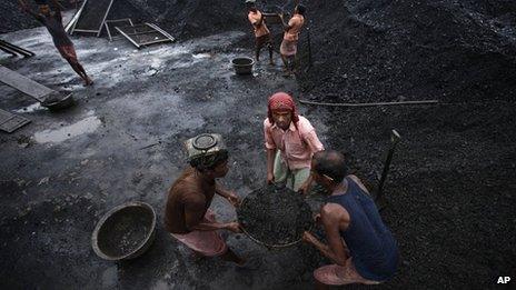 Workers deliver coal at a coal depot in Gauhati, India, Wednesday, Aug. 22, 2012