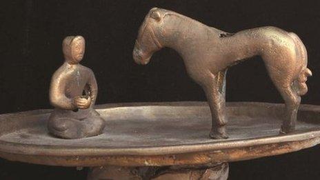 Raised bronze trays featuring a figure kneeling in front of a horse at the Smithsonian Freer and Sackler Asian Art galleries