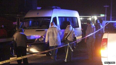 Forensic technicians stand around a white van containing the bodies of several men on a highway on the outskirts of San Luis Potosi, 9 August 2012