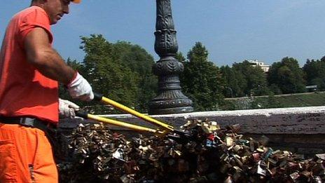 A workman cuts padlocks hanging hanging along the Ponte Milvio bridge in Rome, Italy, 10 September 2012