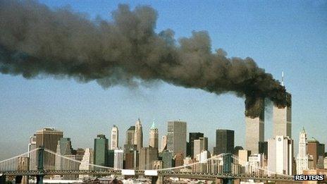 The towers of the World Trade Center pour out smoke shortly after being struck by hijacked airliners in New York in this 11 September 2001 file photograph