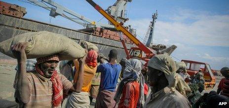 In a photograph released by the African Union-United Nations Information Support Team on 6 August 2012, dock workers load sacks of imported cement inside the seaport of Mogadishu, Somalia