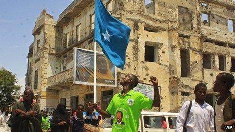 A Somali man wearing T-shirts with a picture of Somalia"s new president Hassan Sheikh Mohamud march through the streets to show his support, in Mogadishu, Somalia, Tuesday, Sept. 11, 2012.