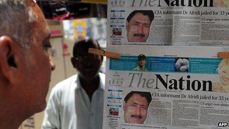 A Pakistani man reads a newspaper bearing the photograph of Shakil Afridi (May 2012)