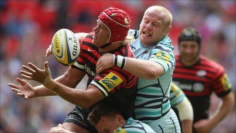 Mouritz Botha of Saracens is tackled by Leicester's Dan Cole and Sam Harrison