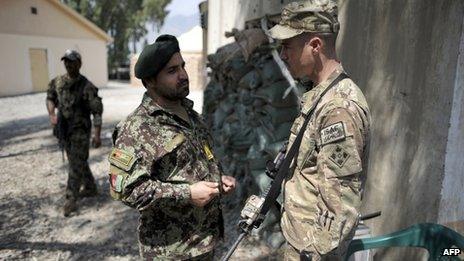 A Afghan officer from the 2nd Kandak, 2nd Brigade, 201st corps of the Afghan National Army and an officer of the 4th brigade combat team 4th infantry division of the US Army talk at Forward Operating Base Joyce, in Kunar