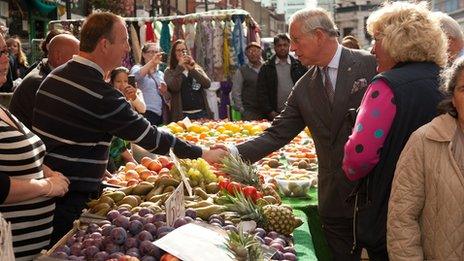 The Prince of Wales is greeted by a market trader during a visit to Surrey Street Market in Croydon, London