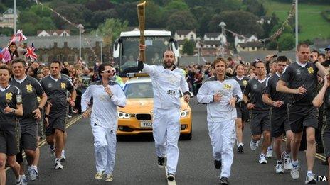 Matt Bellamy, Dominic Howard and Christopher Wolstenholme, Muse, carry the Olympic flame on the leg between Torquay and Teignmouth