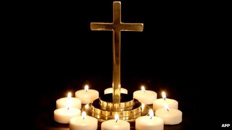 Gold cross surrounded by candles