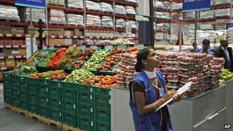 An employee checks the stock inside a newly opened Bharti Wal-Mart store in Hyderabad, India, Wednesday, Sept. 26, 2012