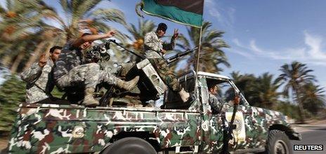 Libyan security forces head to a compound which had been taken over by an armed group in Tripoli 23 September 2012