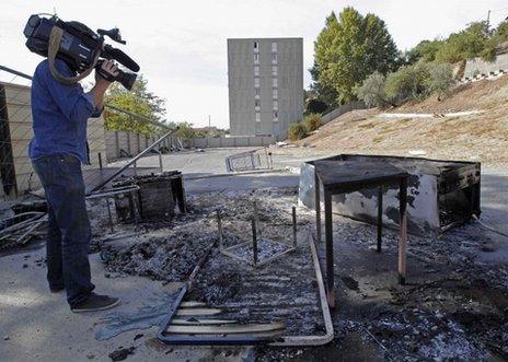 A cameraman films the charred remains of the Roma camp in Marseille, 28 September