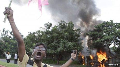 A pro-Telangana supporter shouts slogans near police vehicles which were set on fire by the supporters during a protest in the southern Indian city of Hyderabad September 30, 2012.