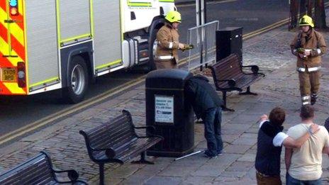 Man with head stuck in bin