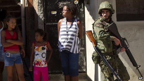 Residents watch soldiers patrolling the Fogo Cruzado slum in Rio de Janeiro ahead of Sunday's municipal elections