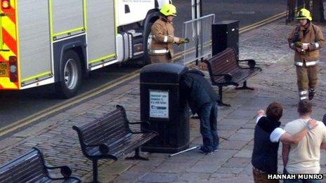 Man with head stuck in bin