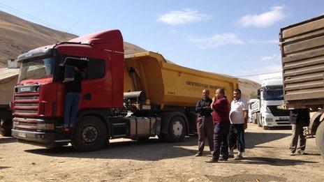 Truck drivers and trucks parked on the Turkish side of the Iranian border