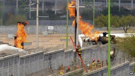 Firefighter climb a ladder as they try to control a fire after an explosion at a gas pipeline distribution centre in Reynosa