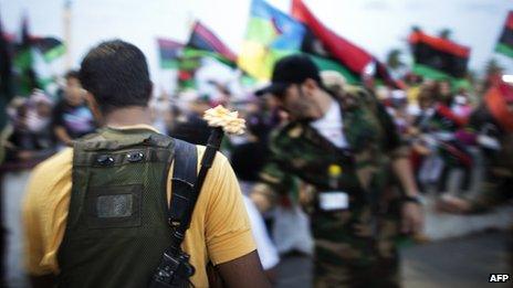 Libyan NTC fighter with a rose in his gun after the death of Gaddafi, October 2011