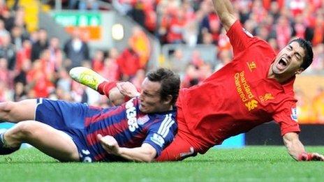 Liverpool's Luis Suarez is challenged by Stoke City's Dean Whitehead (left)