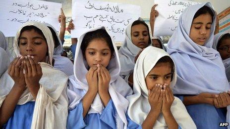 Pakistani schoolgirls in headscarves pray