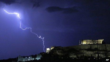 Lightning illuminates the ancient Parthenon temple on top of the Acropolis hill in Athens on 14 October 2012