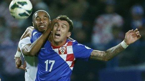 Ashley Williams yn herio Mario Mandzukic, sgoriwr gôl gyntaf Croatia