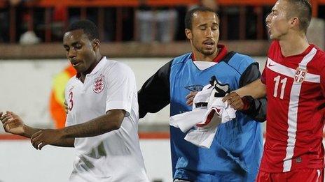 Andros Townsend (centre) of England separates his team-mate Danny Rose (left) and Serbia's Sasa Markovic